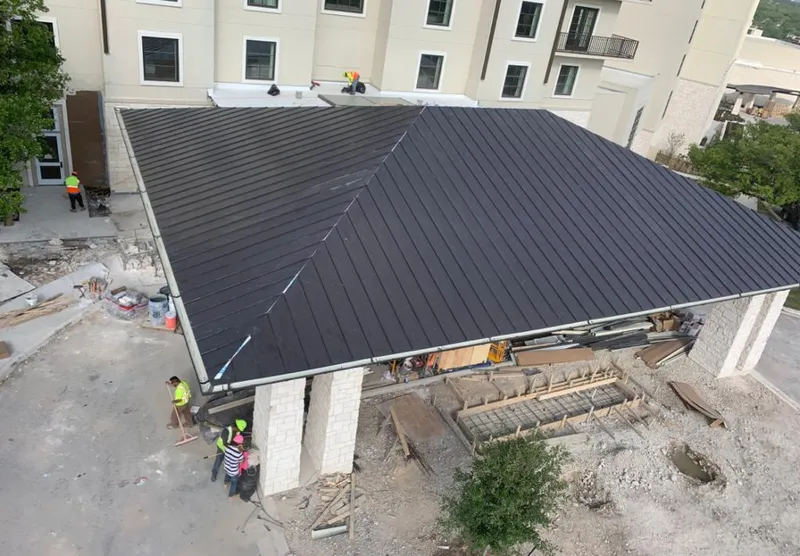 Metal roofing installation team working on a commercial building in Bellevue